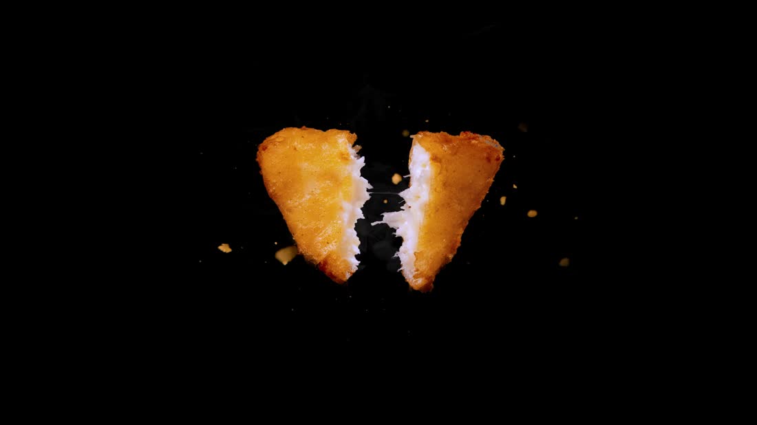 Close-up of a tempura cheese wedge being pulled apart, surrounded by crumbs