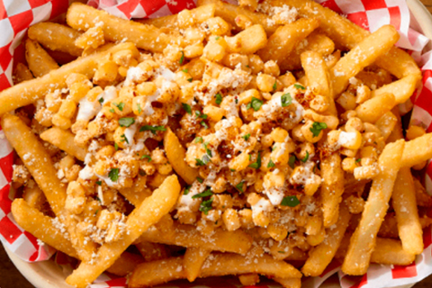 Basket of McCain® SureCrisp® fries topped with corn, cheese, and herbs.