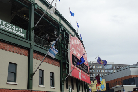 Angled view of the iconic Wrigley Field marquee with flags flying above the Chicago Cubs® entrance.